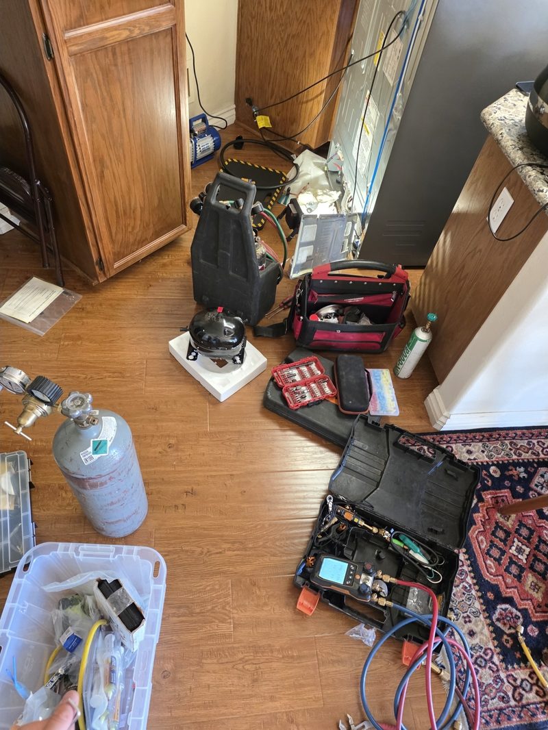 Professional appliance repair toolkit — refrigerant tank, manifold gauges, tool bags